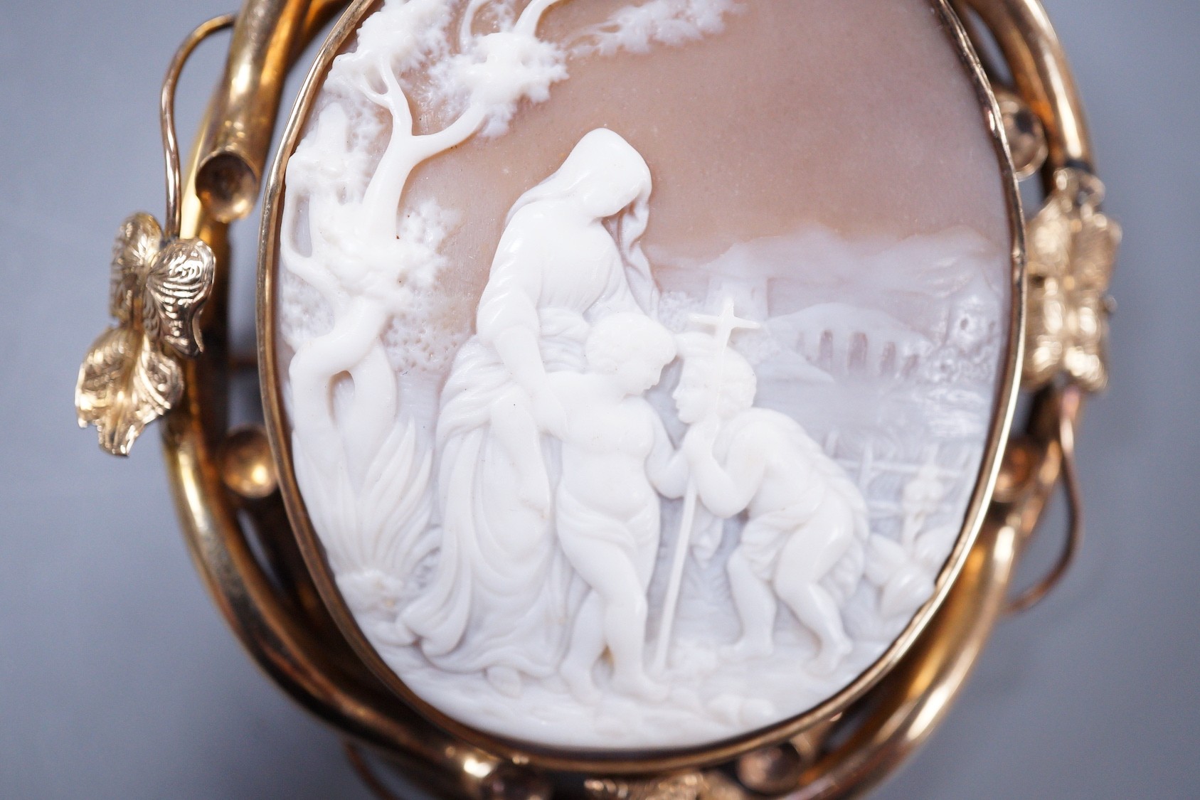 A Victorian yellow metal mounted oval cameo shell brooch, carved with Madonna and child with a young St. John, 70mm